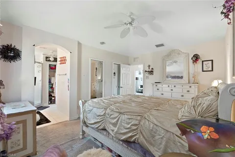 a spacious bedroom with a bed and a chandelier