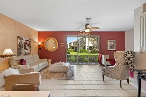 a living room with furniture a clock and a large window