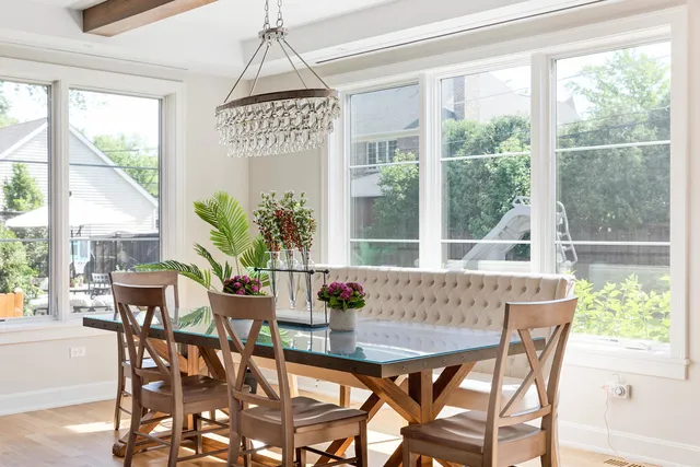 a large white kitchen with a large window a refrigerator and a sink