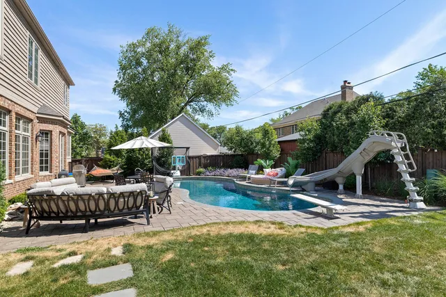 an aerial view of a house with pool garden and trees
