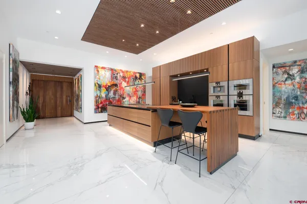 a hallway with furniture and kitchen view