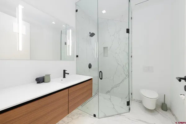 a bathroom with a sink a toilet and shower