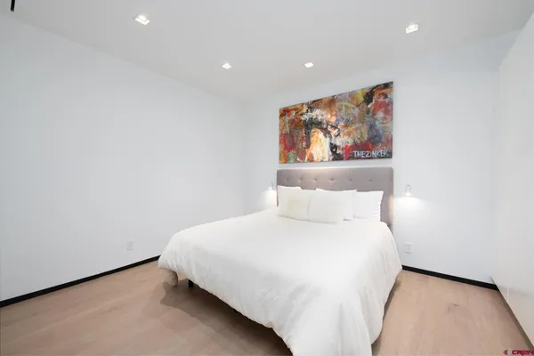 a bedroom with a bed and painting on the wall