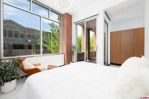 a bedroom with a bed and a large window