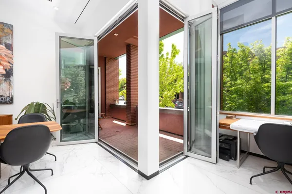 a view of a workspace with furniture and a window