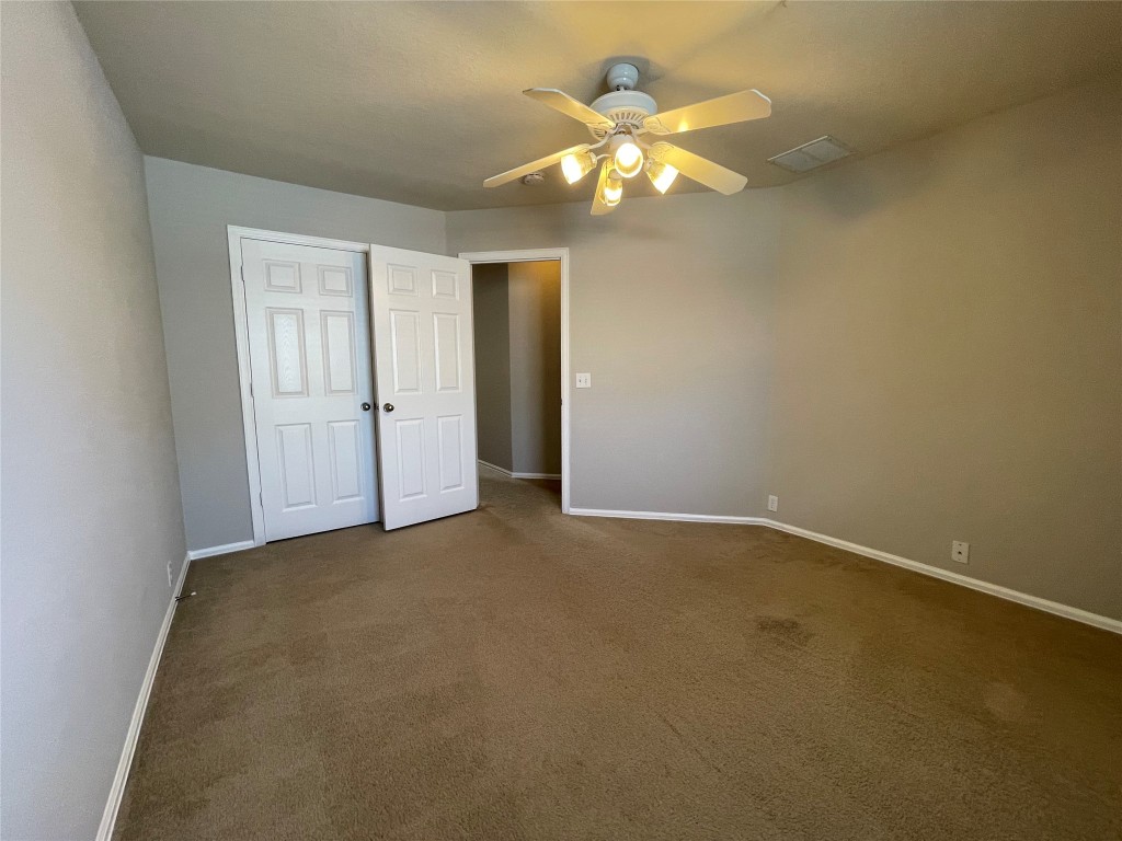 208 Spruce Drive Kyle, TX 78640 - Photo 11 of 26 an empty room with a chandelier fan and closet