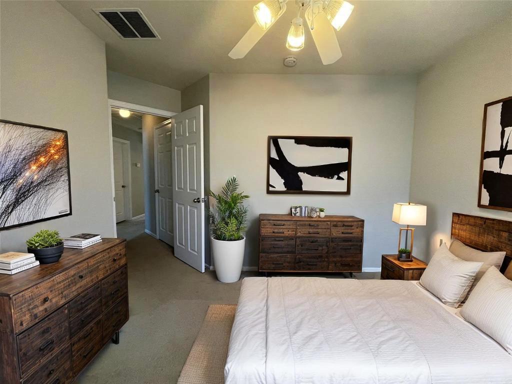 208 Spruce Drive Kyle, TX 78640 - Photo 12 of 26 a bedroom with a bed and a painting on the wall