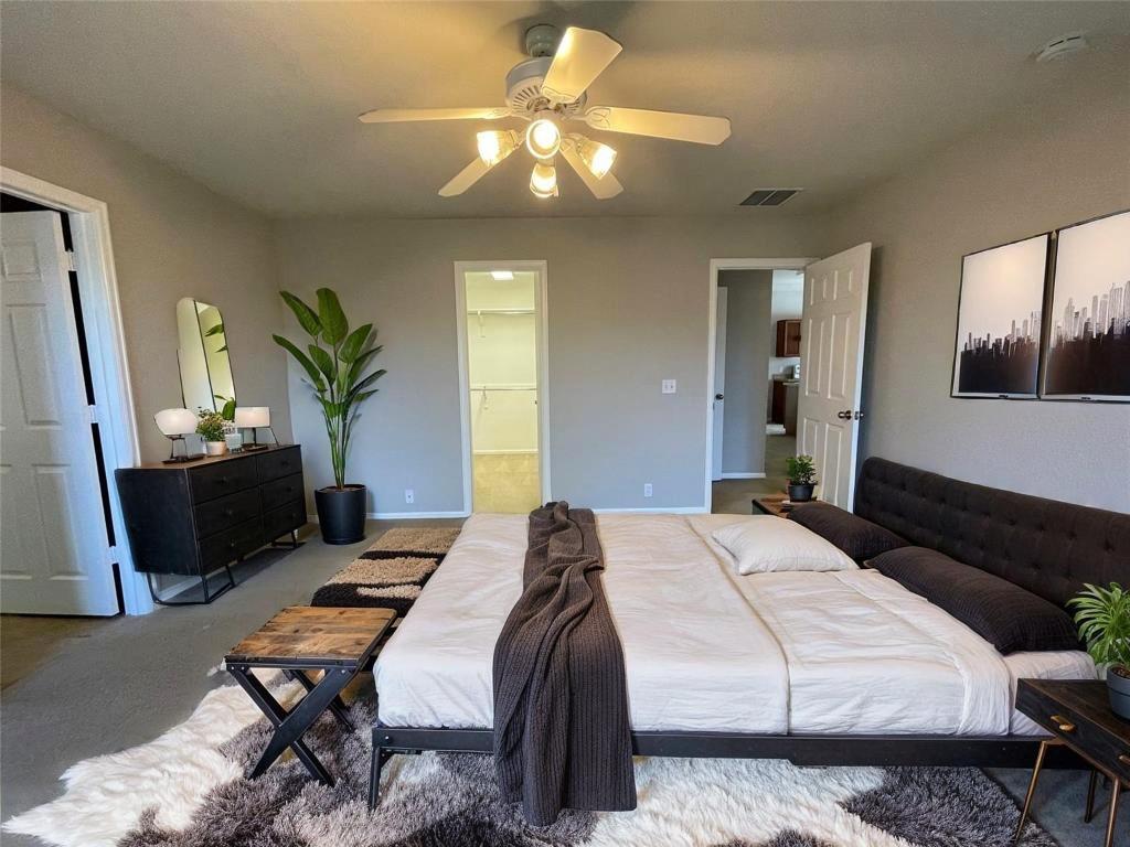 208 Spruce Drive Kyle, TX 78640 - Photo 18 of 26 a bedroom that has a bed and a chandelier