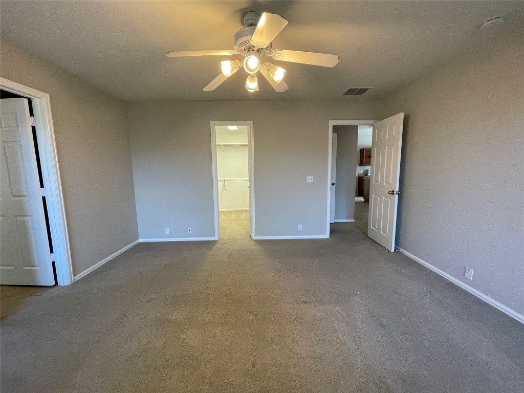 208 Spruce Drive Kyle, TX 78640 - Photo 19 of 26 an empty room with a chandelier fan and windows