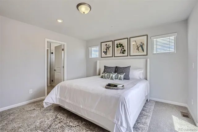 a bedroom with a bed and painting on the wall