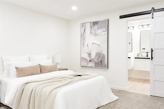 a bedroom with a bed and a painting on the wall