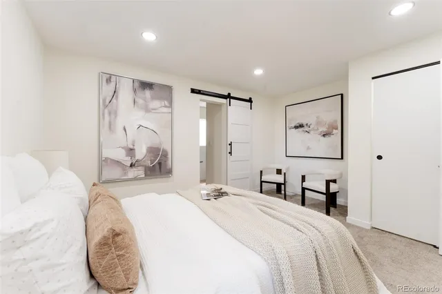 a bedroom with a large bed and a chandelier