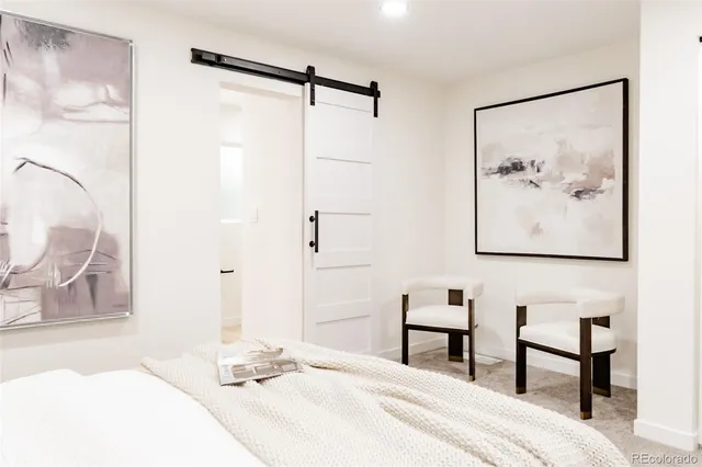 a bedroom with a bed and a painting on the wall