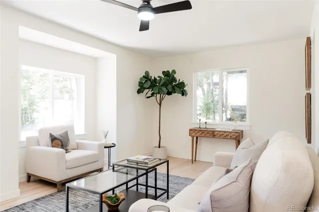 a living room with furniture a window and a potted plant