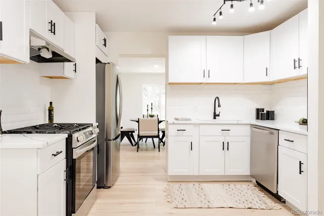 a kitchen with white cabinets and appliances