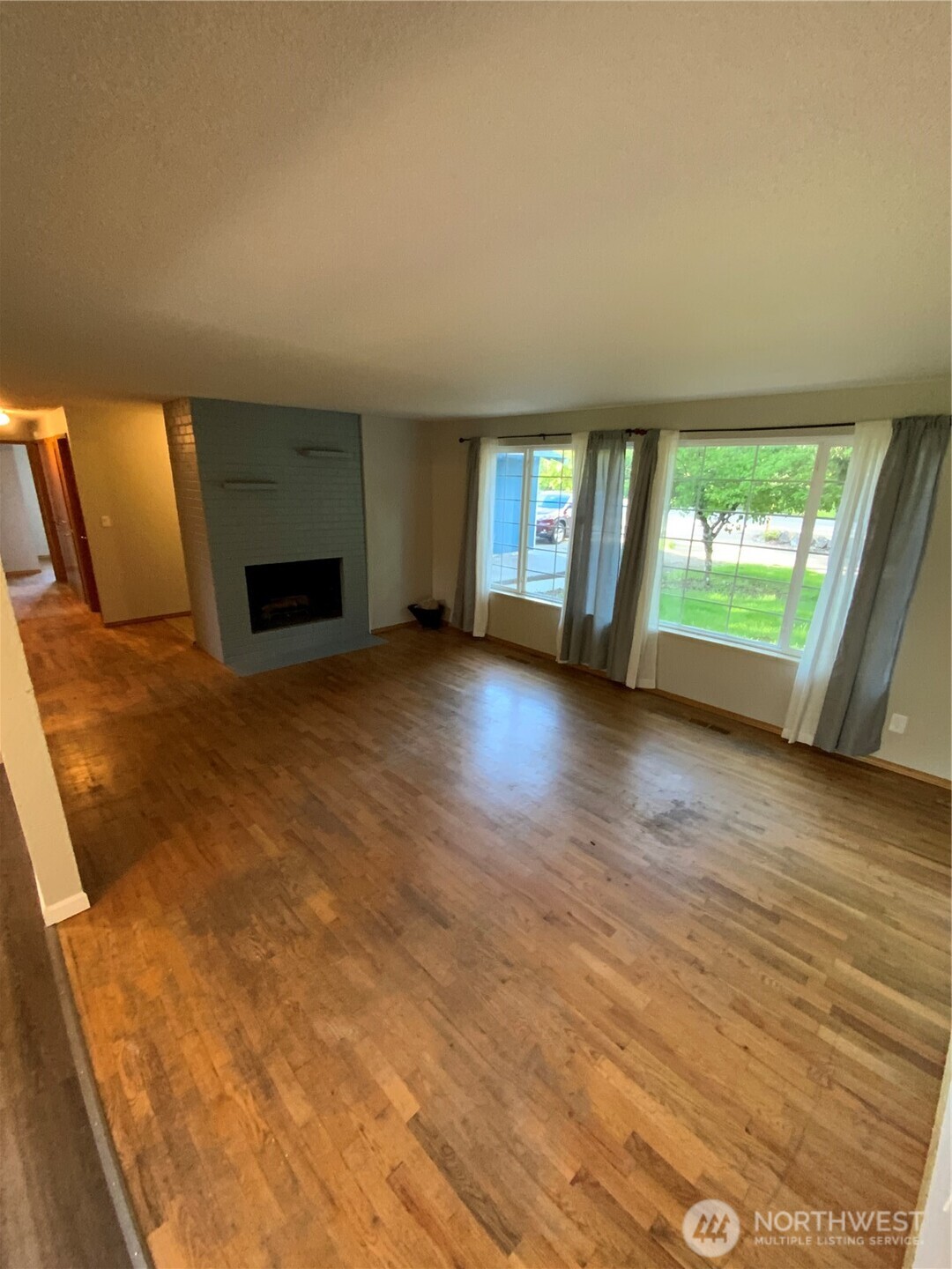 621 Brookdale Road East Tacoma, WA 98445 - Photo 5 of 14 a view of an empty room with a fireplace and a window