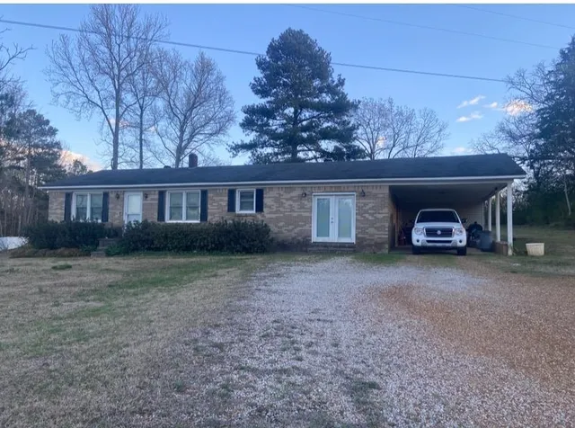 a view of a house with a yard and large tree