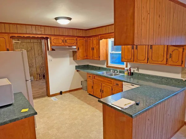 a kitchen that has a sink a refrigerator and a window