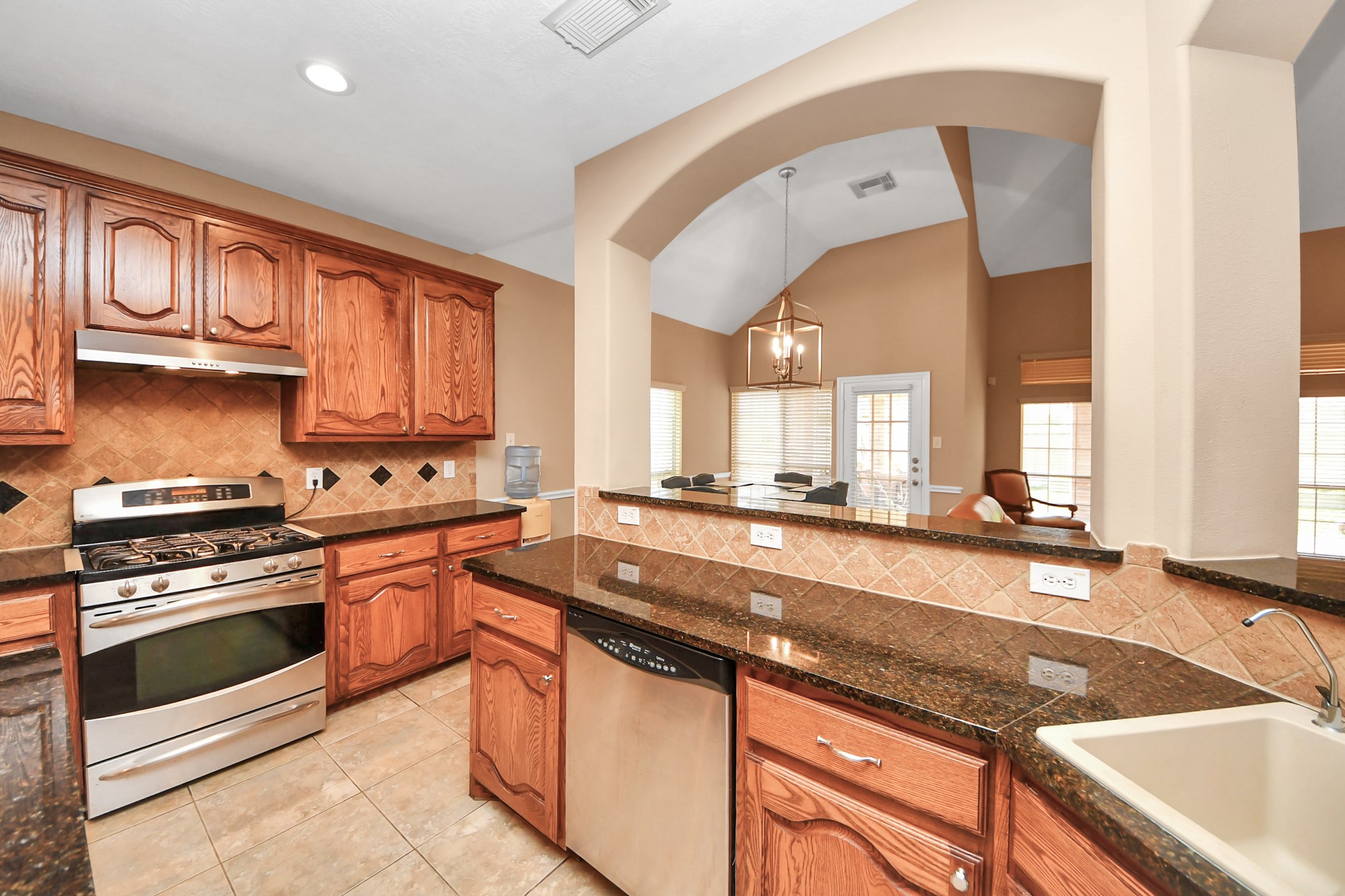 706 River Delta Lane Rosenberg, TX 77469 - Photo 11 of 50 a kitchen with stainless steel appliances granite countertop a sink a stove and a microwave
