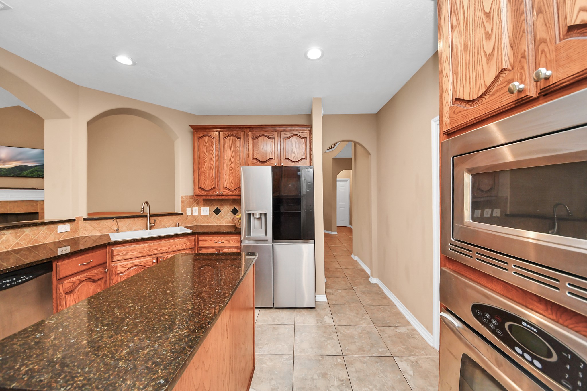 706 River Delta Lane Rosenberg, TX 77469 - Photo 14 of 50 a kitchen with granite countertop a refrigerator and a sink