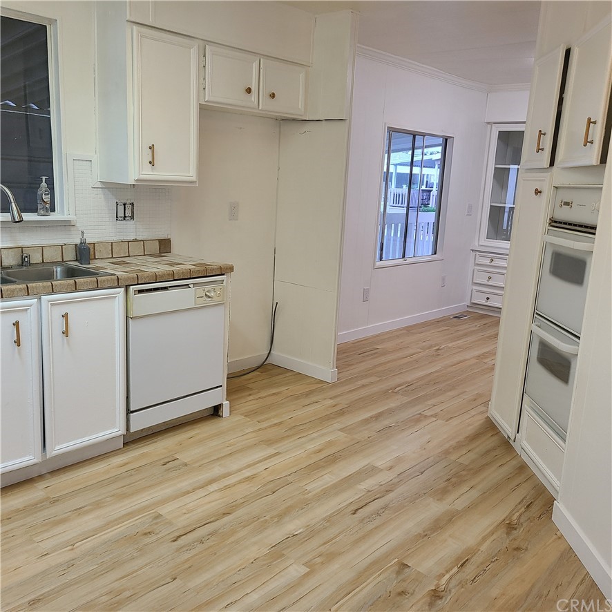 3700 Buchanan, Unit 98 Corona, CA 92503 - Photo 13 of 24 a kitchen with granite countertop white cabinets and white appliances