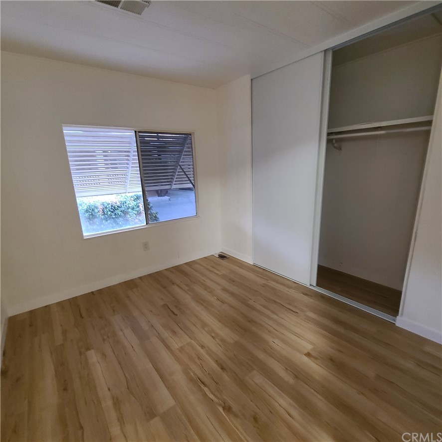 3700 Buchanan, Unit 98 Corona, CA 92503 - Photo 8 of 24 an empty room with wooden floor and windows