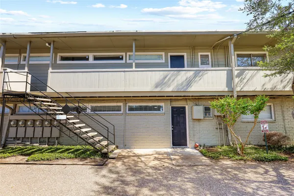 a view of a house with a yard and potted plants