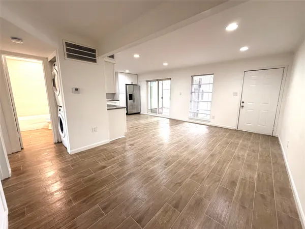 a view of empty room with wooden floor and window