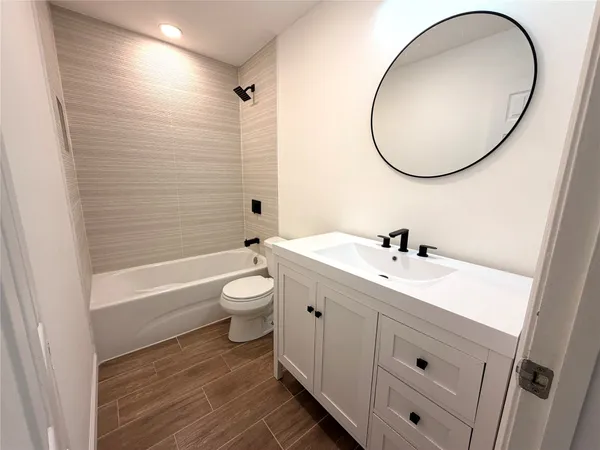 a bathroom with a double vanity sink toilet mirror and bathtub