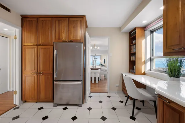 a kitchen with stainless steel appliances a refrigerator a table and chairs in it