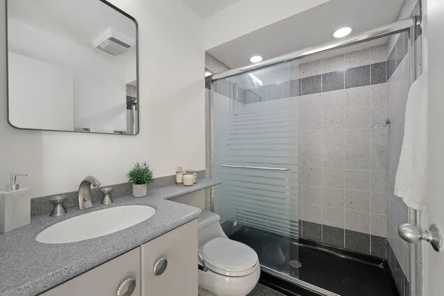 a bathroom with a sink a toilet and shower