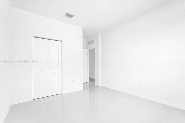 a view of a room with wooden floor and a window
