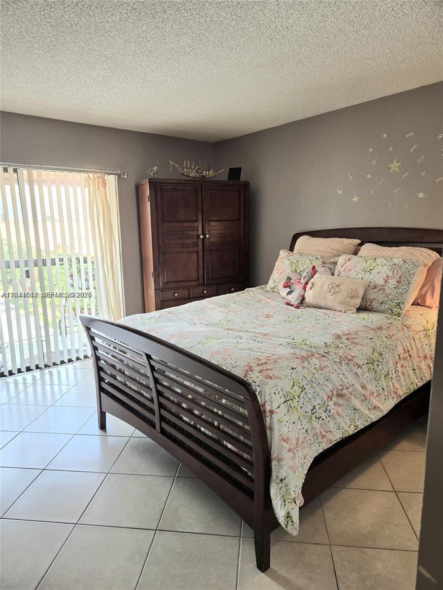 2174 West 60th Street, Unit 17205 Hialeah, FL 33016 - Photo 7 of 11 a bedroom with a bed and a dresser
