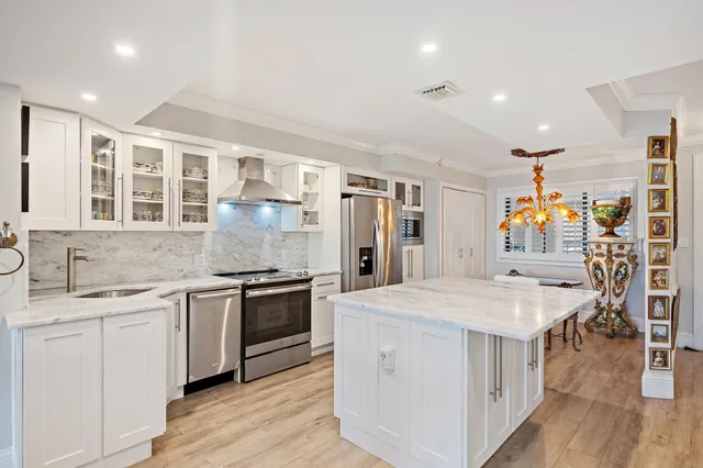 a kitchen with a stove a sink a refrigerator and cabinets
