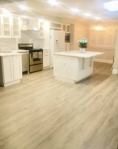 a large white kitchen with granite countertop a sink