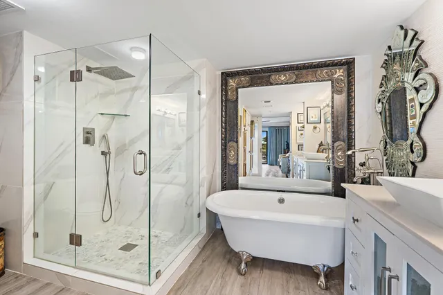 a bathroom with a tub shower and mirror