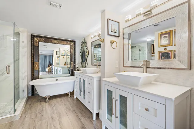 a bathroom with a sink vanity granite tub and a mirror