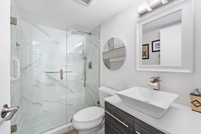 a bathroom with a sink toilet a mirror and shower