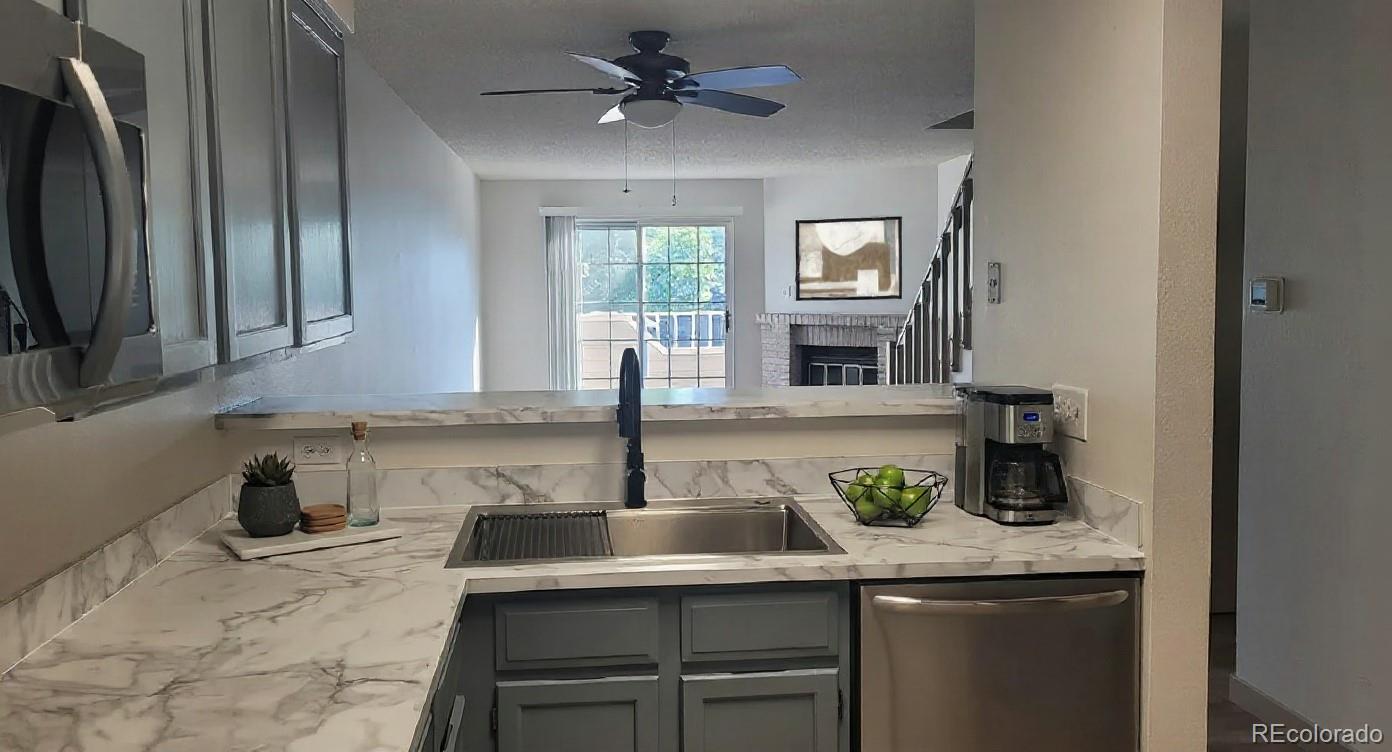 1818 South Quebec Way, Unit 57 Denver, CO 80231 - Photo 4 of 28 a kitchen with granite countertop a sink a counter top space and cabinets