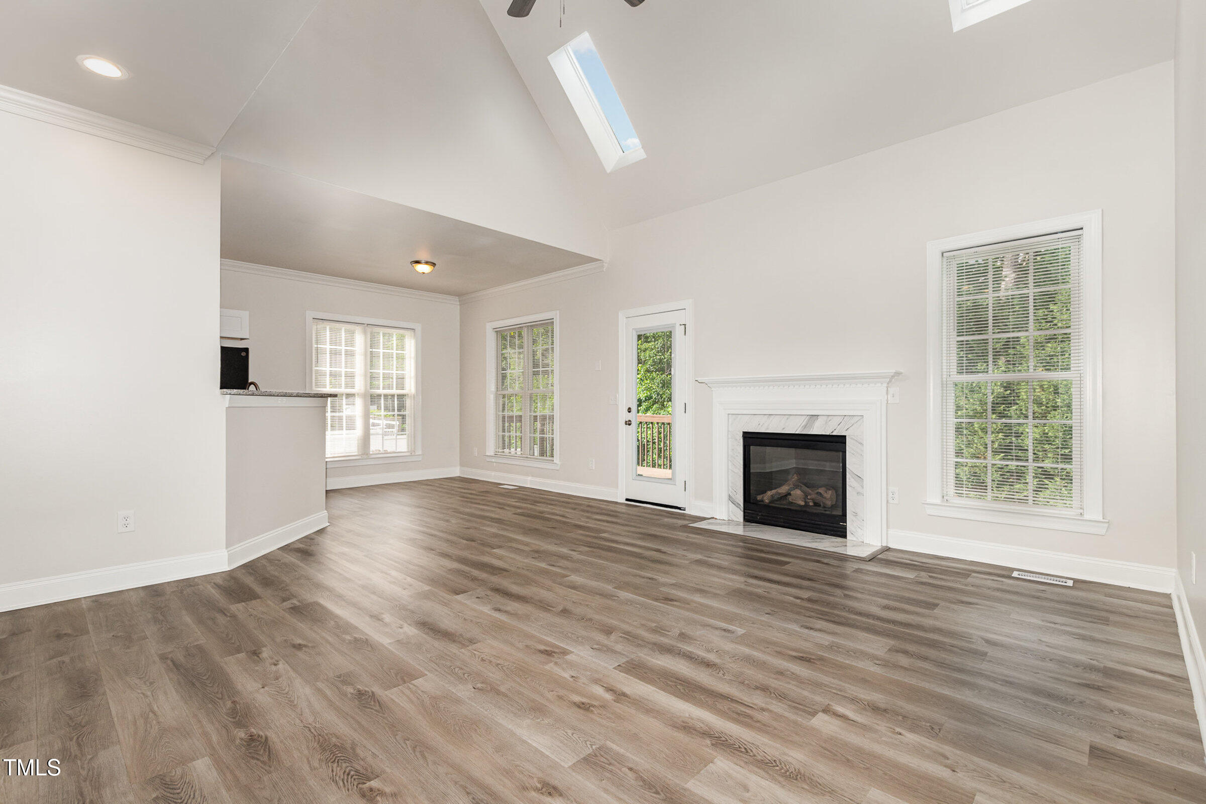7936 Milltrace Run Raleigh, NC 27615 - Photo 2 of 21 an empty room with wooden floor fireplace and windows