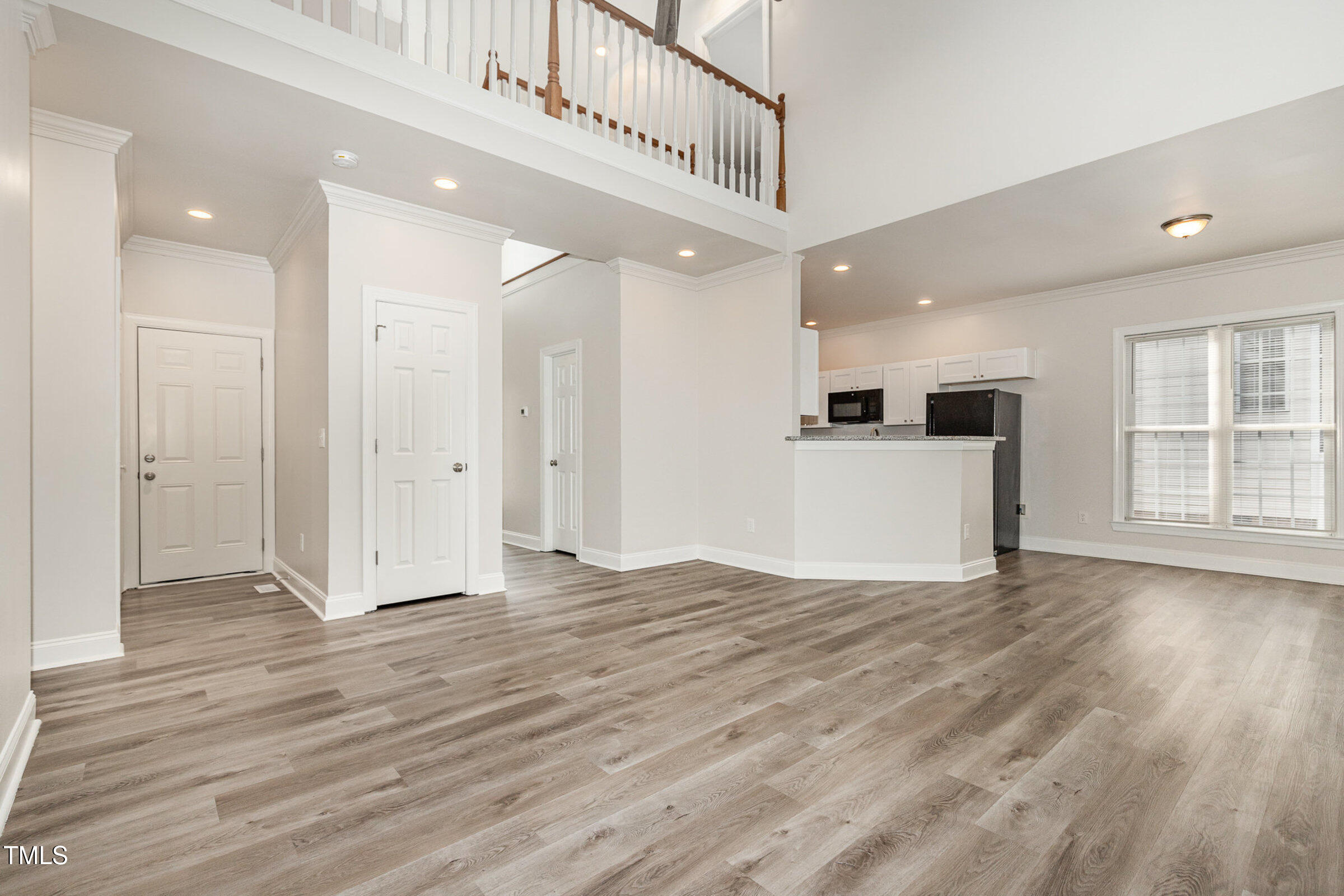 7936 Milltrace Run Raleigh, NC 27615 - Photo 4 of 21 a view of an empty room with wooden floor and kitchen