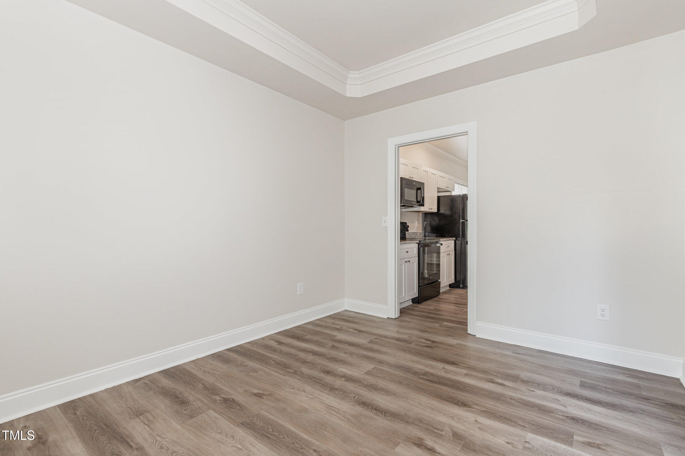7936 Milltrace Run Raleigh, NC 27615 - Photo 9 of 21 a view of an empty room with wooden floor