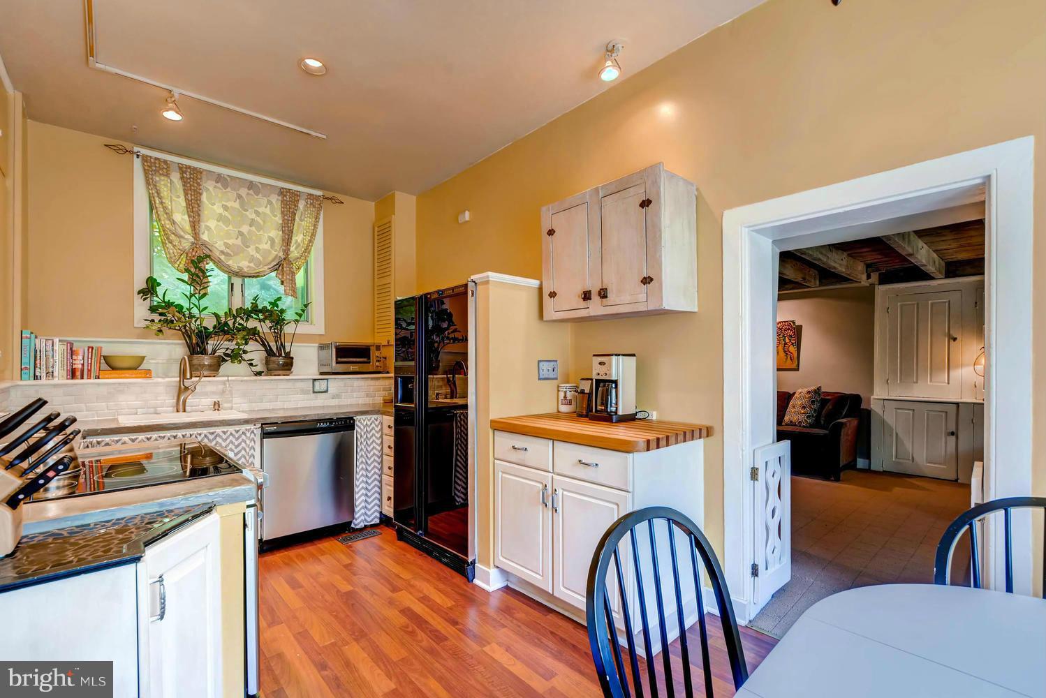 5106 North Franklintown Road Baltimore, MD 21207 - Photo 7 of 22 a kitchen with stainless steel appliances granite countertop a refrigerator a stove top oven a sink dishwasher and white cabinets with wooden floor