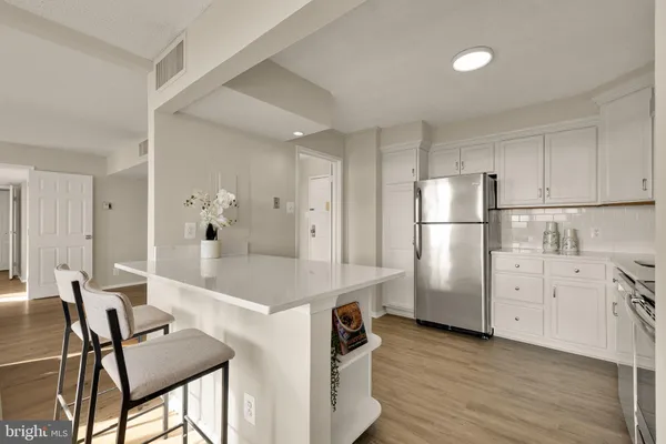 a kitchen with refrigerator cabinets and wooden floor