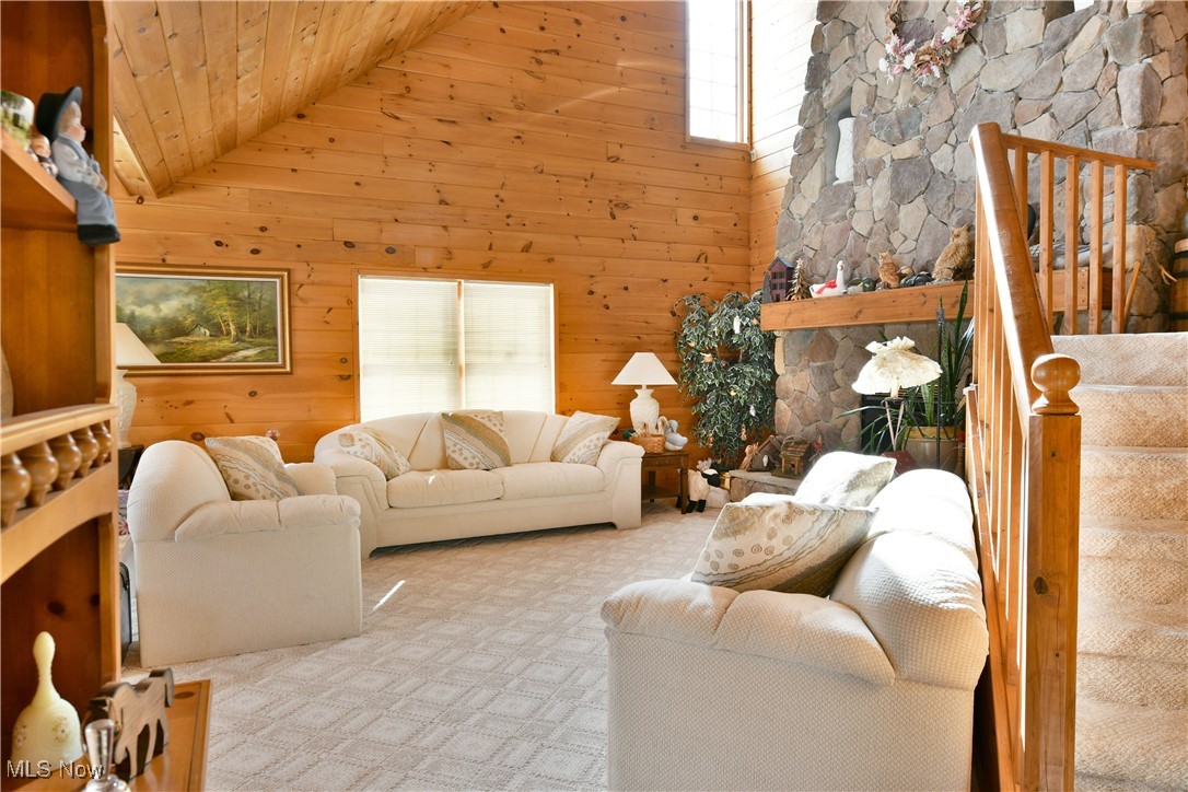 3339 Bushnell Campbell Road Fowler, OH 44418 - Photo 11 of 50 Living room featuring light carpet, wood ceiling, stairs, wood walls, and high vaulted ceiling
