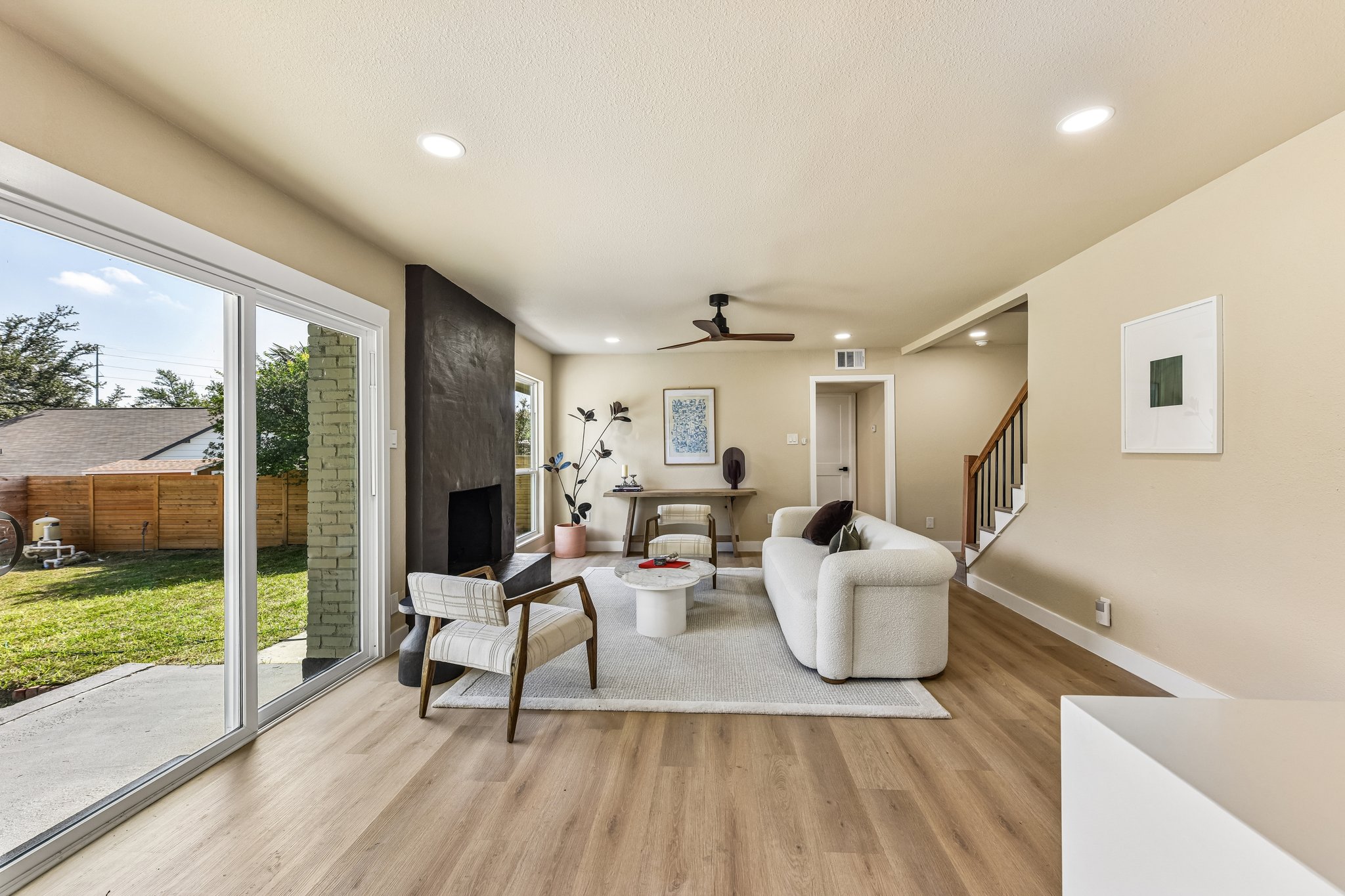 7523 Glenhill Road Austin, TX 78752 - Photo 16 of 38 Natural light floods this inviting living area, highlighting warm wood floors and a contemporary fireplace feature.