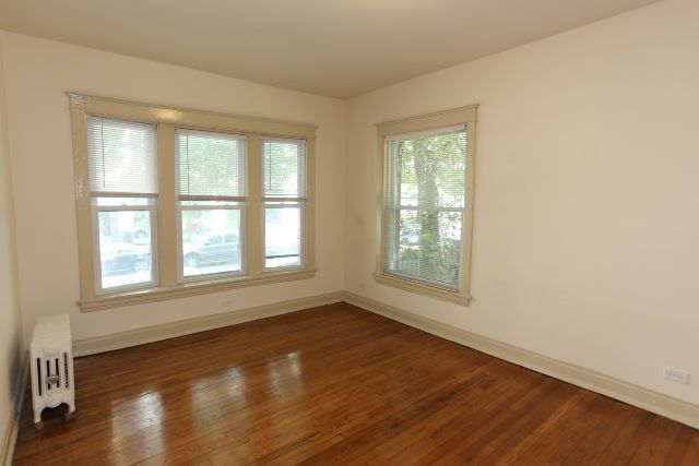 4716 North Racine Avenue, Unit 2E Chicago, IL 60640 - Photo 16 of 19 an empty room with wooden floor and windows