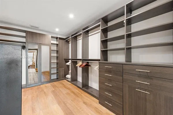 a view of walk in closet with empty racks