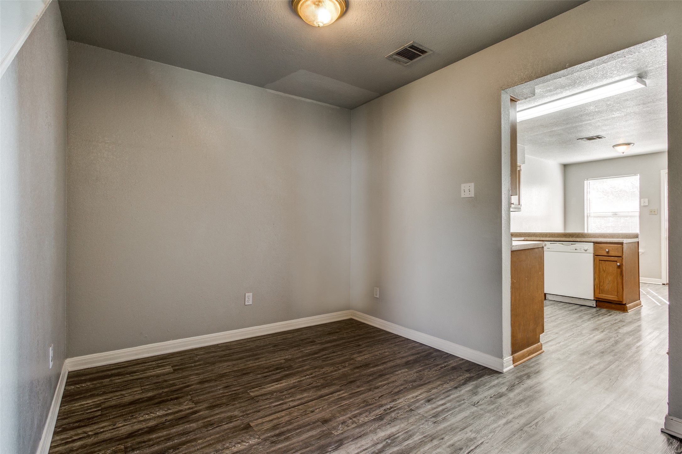 106 Verna Spur, Unit B Georgetown, TX 78628 - Photo 7 of 25 Streamlined flooring extends through this adaptable space, offering a smooth transition to the adjacent kitchen.