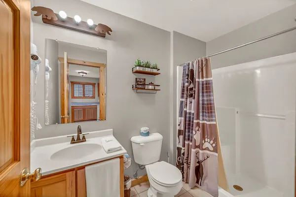 a white toilet sitting next to a bathroom sink and a shower